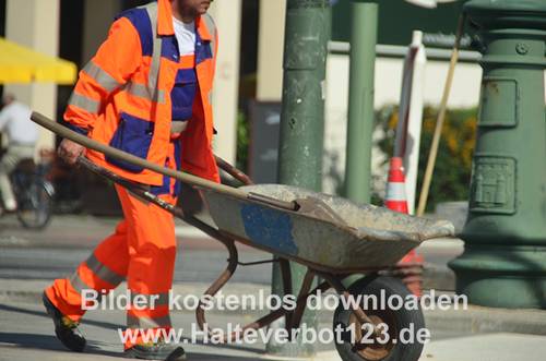 Großaufnahme eines Straßenbauarbeiters mit einer Schubkarre